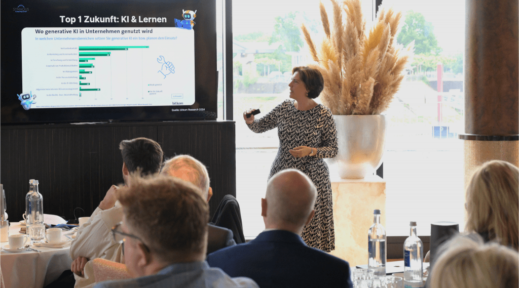 Martha Giannakoudi (Ai Trainierin) hält einen Vortrag beim KI Business Breakfast in einem gefüllten Raum im Hyatt Düsseldorf