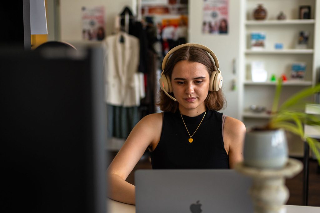 Junge Frau arbeitet konzentriert am Computer mit Schatten-KI
